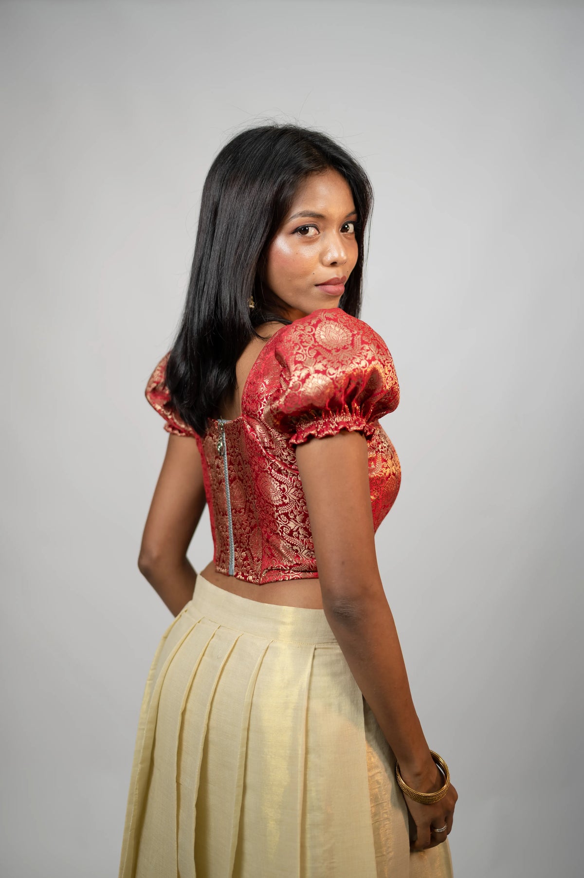 Crimson Noor crimson brocade puff sleeve corset showing back zipper and gold motifs
