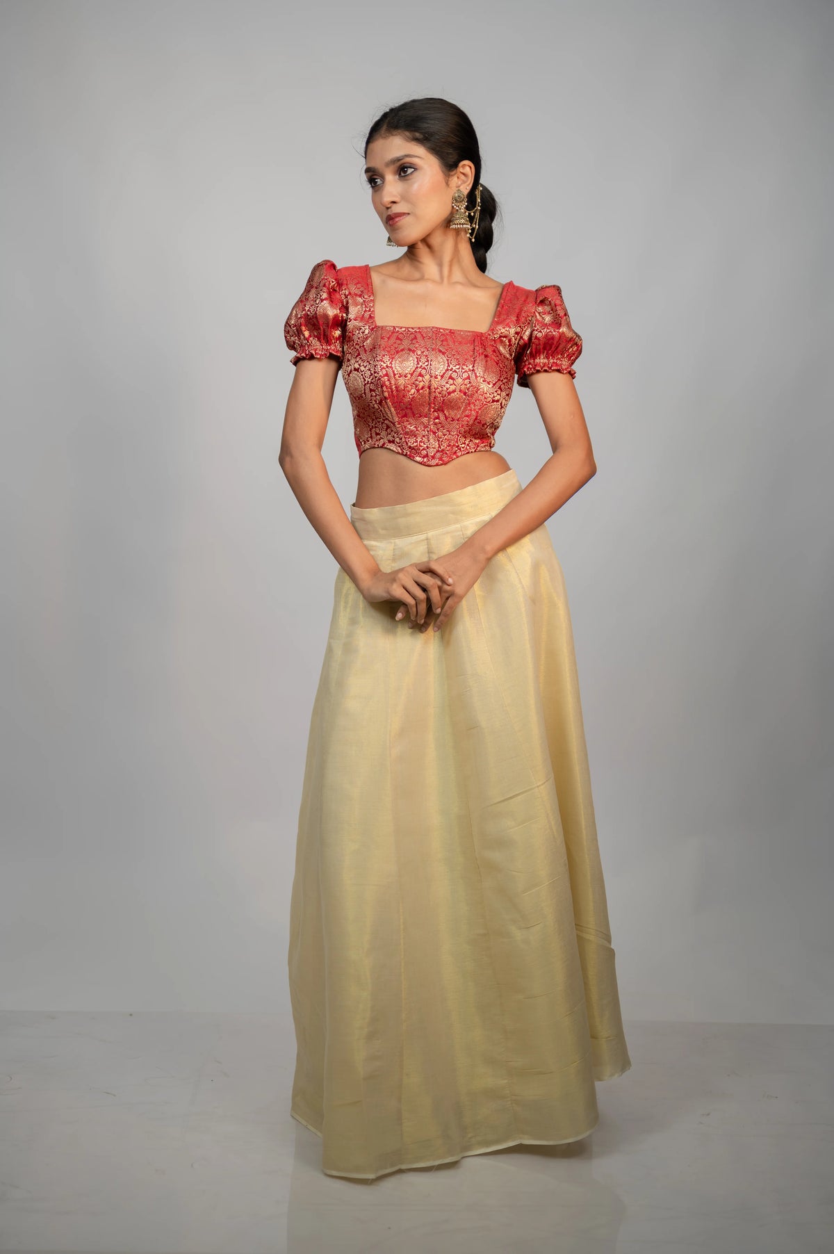Model wearing Crimson Noor crimson brocade puff sleeve corset with ivory skirt